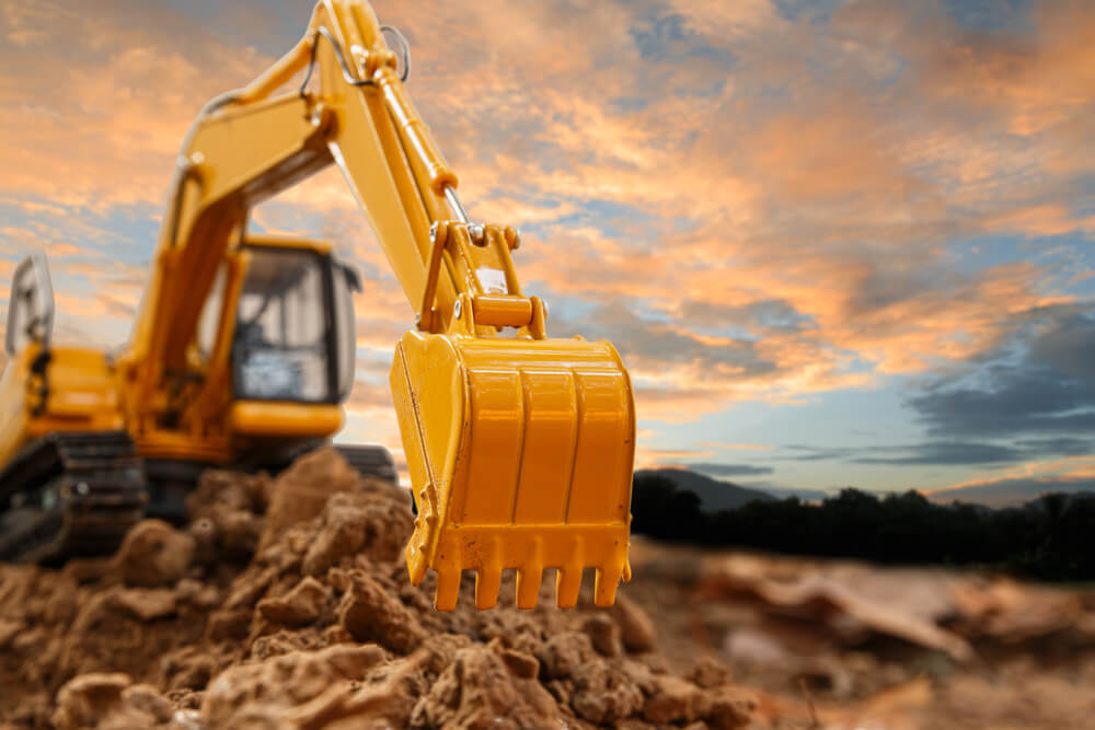 Excavator With Bucket Lift Up Are Digging The Soil In The Construction Site On The Sky Background